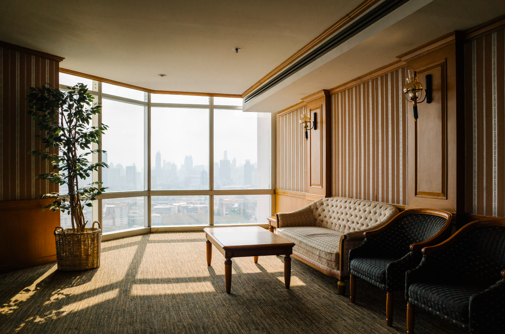 Modern luxury hotel guestroom interior with contemporary architectural design and wide cityscape window view.